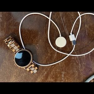 Fossil smart watch with charging cord.